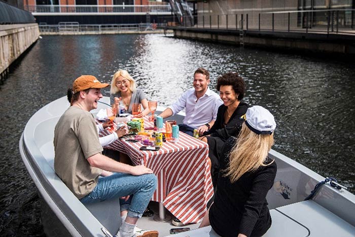 A group of people sitting in a boat on the water, enjoying a serene and peaceful day out on the lake