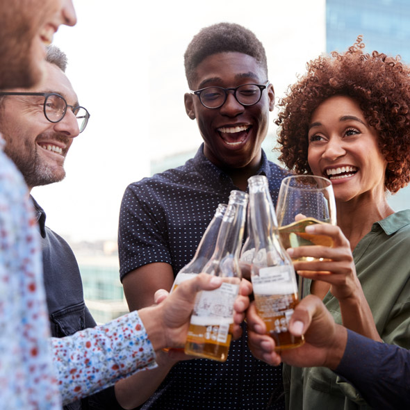 Happy creative business colleagues having a drink after work raise glasses to make a toast