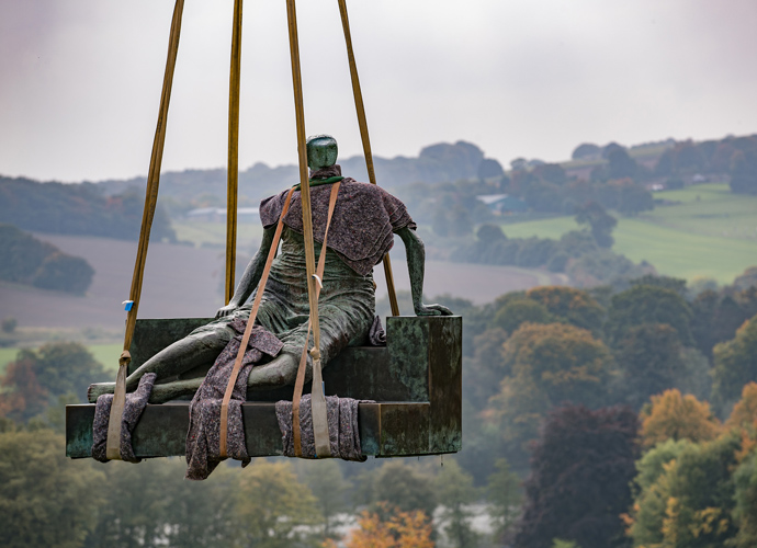 Statue of "Drape Seated Woman" being placed